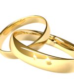 Two gold rings — reflected candles Two linked gold rings. Two candles reflected in the gold. Shallow depth of field.